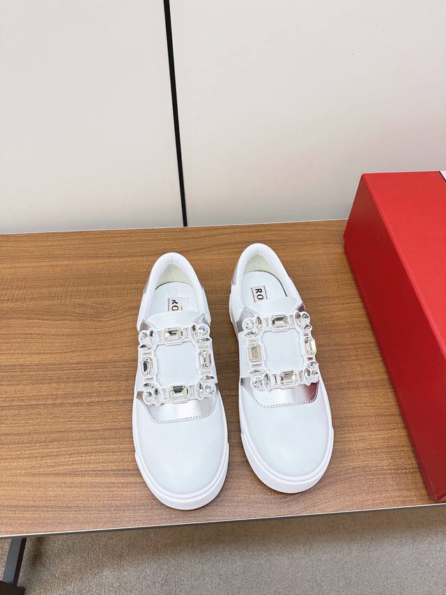 顶级品质 Roger Vivier 新款一脚蹬小白鞋 本季新款简便运动鞋以鞋底花型图案令人眼前一亮 巧妙释合都市时尚与实用功能 本款运动鞋以柔软皮革制成 点缀闪